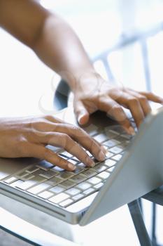 Royalty Free Photo of a Woman's Hands Typing on a Laptop Keyboard