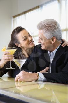 Royalty Free Photo of a Couple Sitting at a Bar With Cocktails