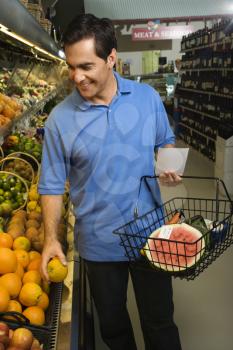 Caucasian mid-adult male grocery shopping for fruit.