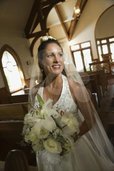 Royalty Free Photo of a Bride Holding a Bouquet Leaving a Church