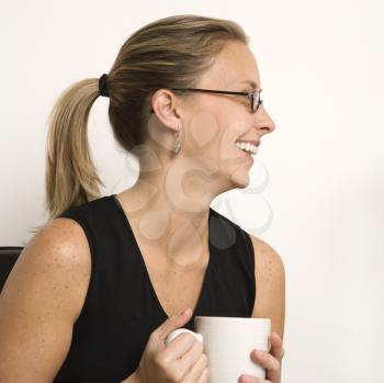 Royalty Free Photo of a Smiling Woman Holding a Coffee Cup