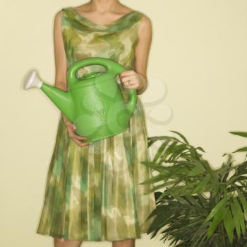 Royalty Free Photo of a Woman Wearing a Vintage Dress Holding a Green Watering Can