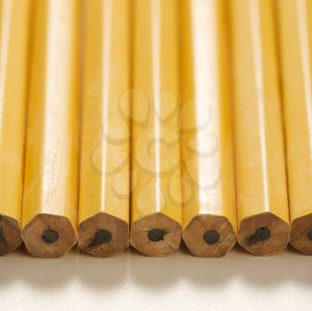 Close up of group of new unsharpened pencils lined up in an even row. 