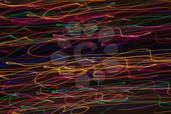 Multicolored lights forming abstract squiggle pattern from motion blur.