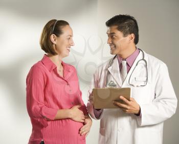 Royalty Free Photo of a Doctor Consulting With His Pregnant Patient