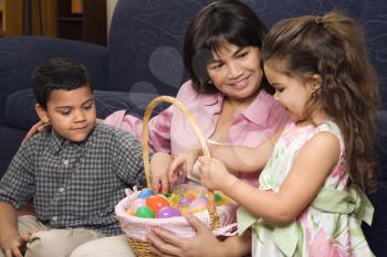 Royalty Free Photo of a Mother With Her Son and Daughter at Home Looking Through an Easter Basket