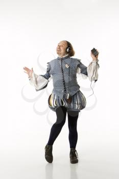 Royalty Free Photo of William Shakespeare in Period Clothing Listening to an MP3 Player and Dancing