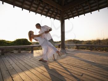 Royalty Free Photo of a Couple dancing under gazebo at the beach
