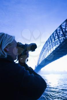 Royalty Free Photo of a Male Photographing Sydney Harbour Bridge at Dusk 