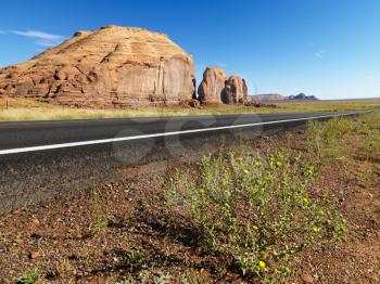 Royalty Free Photo of a Road in a Scenic Desert Landscape With Butte Land Formation
