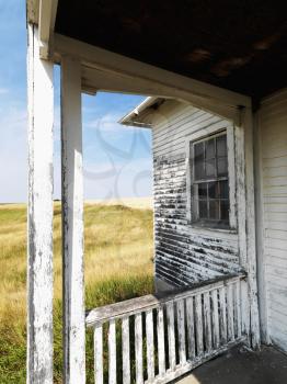 Royalty Free Photo of a View From a Porch of a Weathered Abandoned Building in a Grassland