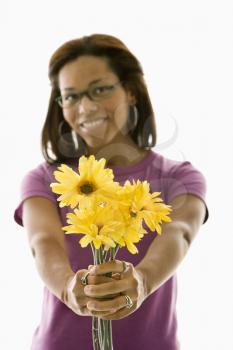 Royalty Free Photo of a Woman Holding Out a Bouquet of Flowers