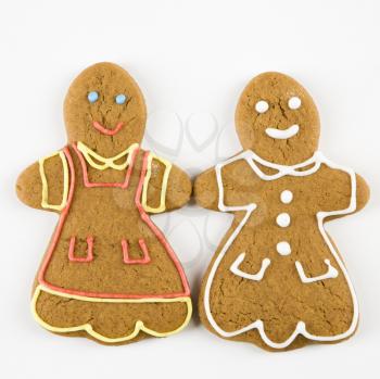 Two female gingerbread cookies holding hands.