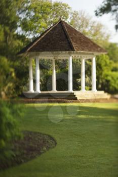 Gazebo is surrounded by park greenery. Vertical shot.