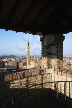 High angle view of Piazza del Campo and surrounding buildings in Siena, Italy, seen from a covered rooftop vantage point. Vertical shot.