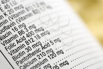 Closeup of a dietary supplement label listing the vitamins contained within each tablet. Horizontal shot.