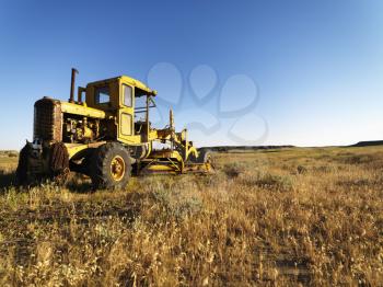 Old grader in a field in the country. Horizontal shot.