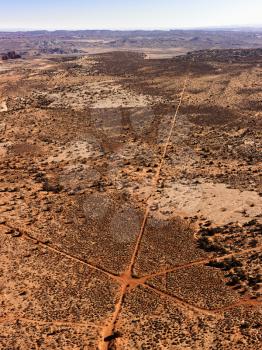 Aerial of intersecting dirt roads in a desert landscape. Vertical shot.