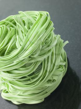 Royalty Free Photo of a Stack of Spinach Noodles on a Black Background