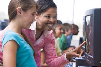 Royalty Free Photo of a Teacher Helping a Student at a Computer