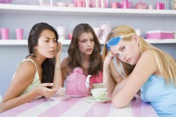 Royalty Free Photo of a Woman With a Hangover Sitting With Two Friends