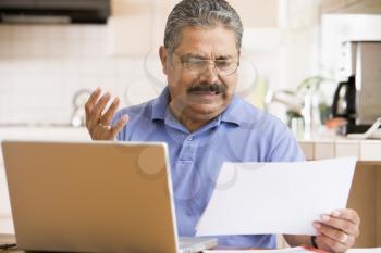 Royalty Free Photo of a Man Looking Frustrated While Holding a Paper