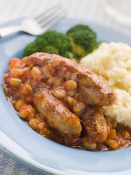 Royalty Free Photo of Sausage and Baked Bean Casserole with Mashed Potato and Broccoli