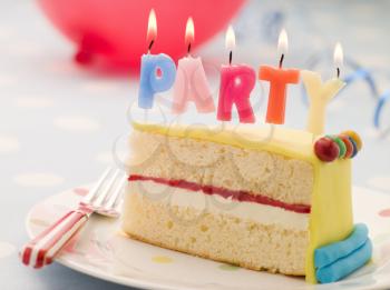 Royalty Free Photo of Party Candles on a Slice of Birthday Cake