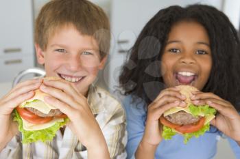 Royalty Free Photo of Two Children Eating Burgers