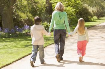 Royalty Free Photo of a Mother and Her Children Walking on a Path