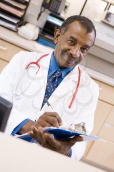 Royalty Free Photo of a Doctor Writing on a Clipboard
