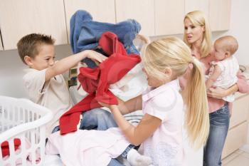 Royalty Free Photo of Children Fighting While Doing Laundry