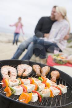 Royalty Free Photo of a Couple Barbecuing at the Beach