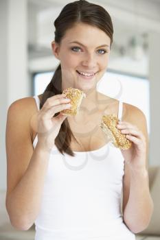 Royalty Free Photo of a Girl Eating a Brown Bread Roll