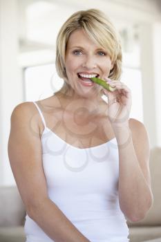 Royalty Free Photo of a Woman Eating a Celery Stick