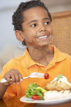 Royalty Free Photo of a Young Boy Having a Meal