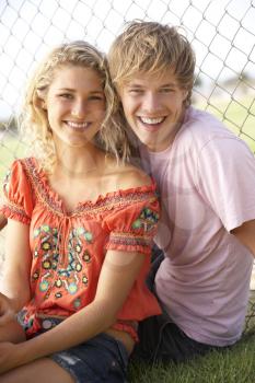 Teenage Couple Sitting In Playground