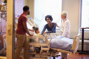 Pediatrician Visiting Parents And Child In Hospital Bed