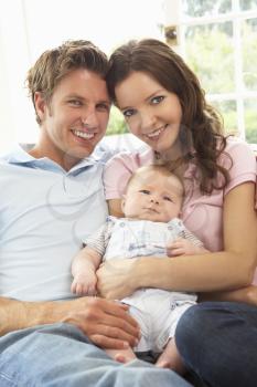 Parents Cuddling Newborn Baby Boy At Home