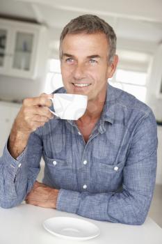Mid age man with coffee at home