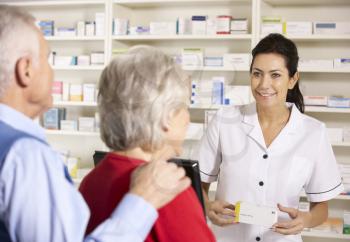 American pharmacist dispensing to senior couple