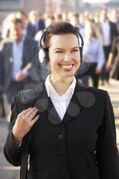 Female commuter in crowd wearing headphones