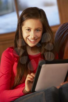 Teenage Girl Relaxing On Sofa With Tablet Computer