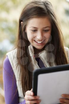 Teenage Girl Using Tablet Computer Outdoors Wearing Winter Clothes