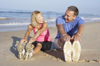 Senior Couple Exercising On Beach