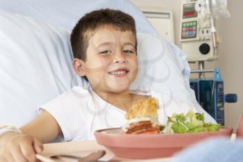 Boy Eating Meal In Hospital Bed