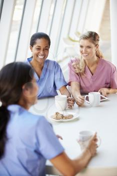 Group Of Nurses Chatting In Modern Hospital Canteen