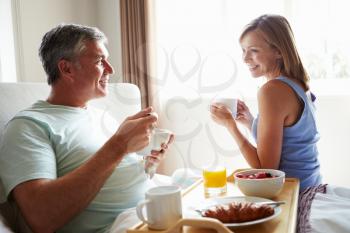 Wife Bringing Husband Breakfast In Bed On Tray
