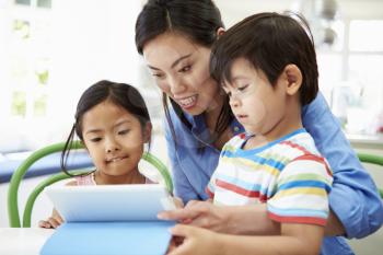 Mother Helping Children With Homework Using Digital Tablet