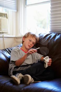 Boy Discovering Parent's Pack Of Cigarettes At Home